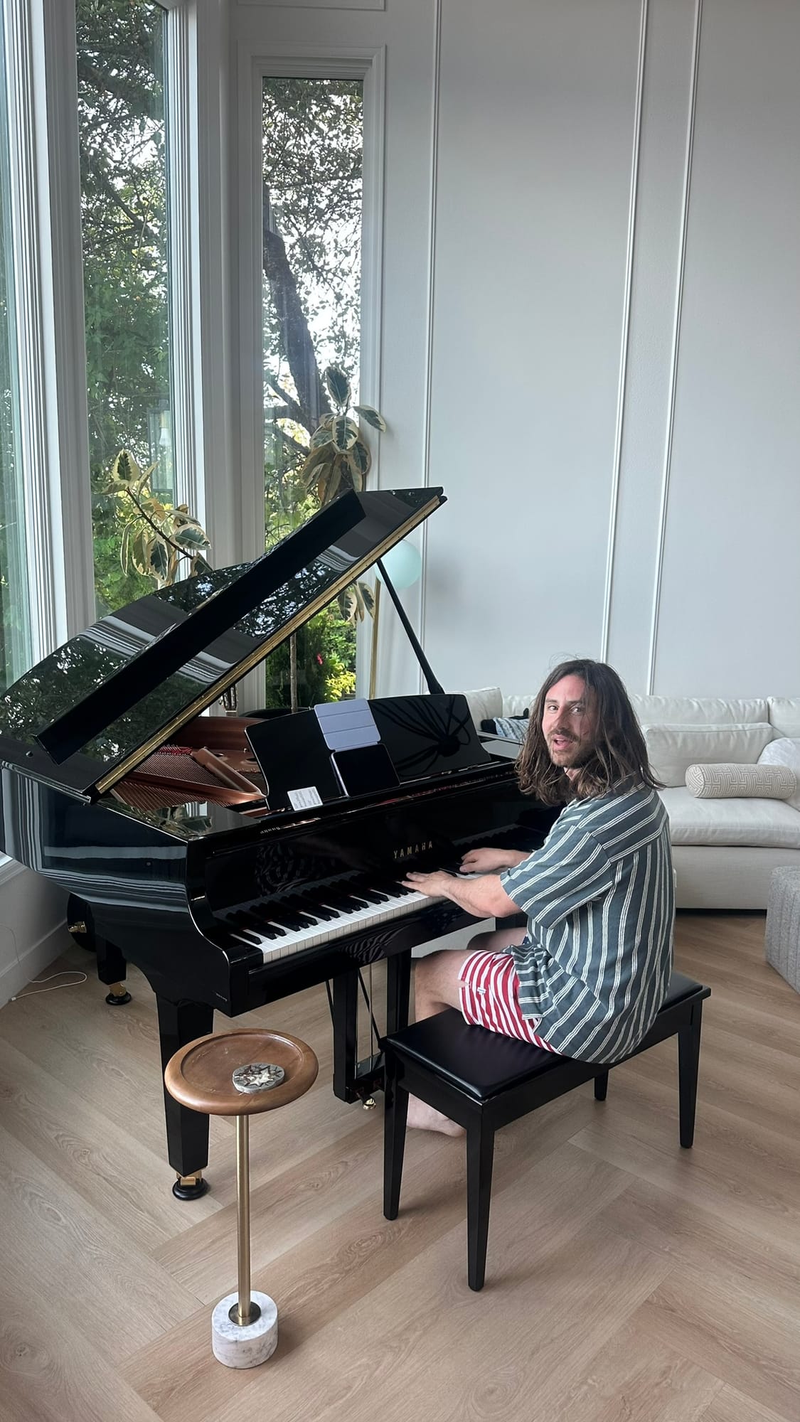 Friend playing the grand piano at the lakeside house