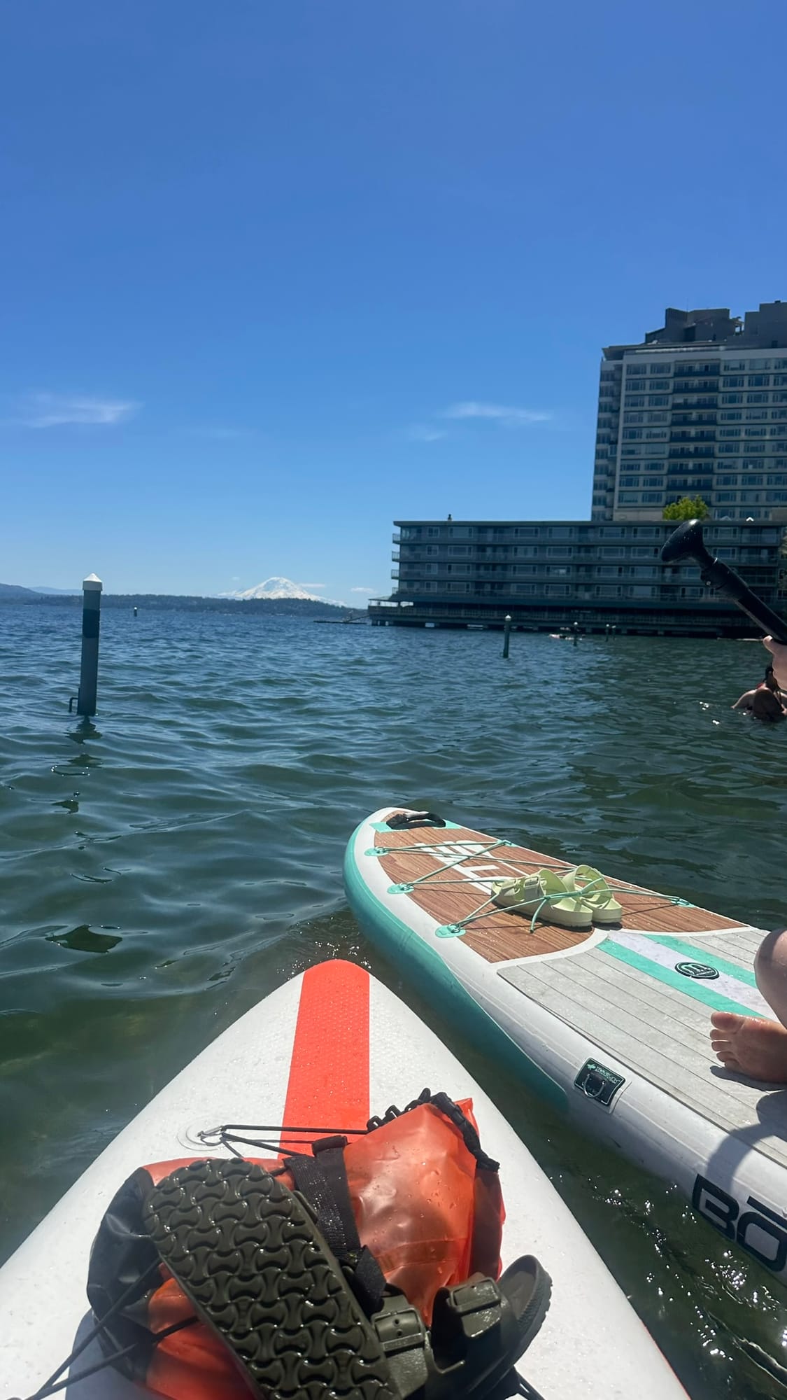 Two paddleboards side by side on the lake with Rainier in the background