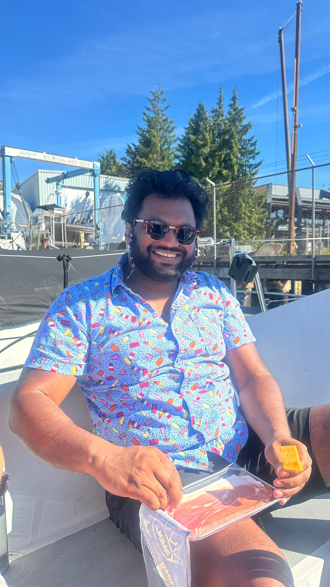 Friend on the sailboat in a popsicle-print shirt with charcuterie