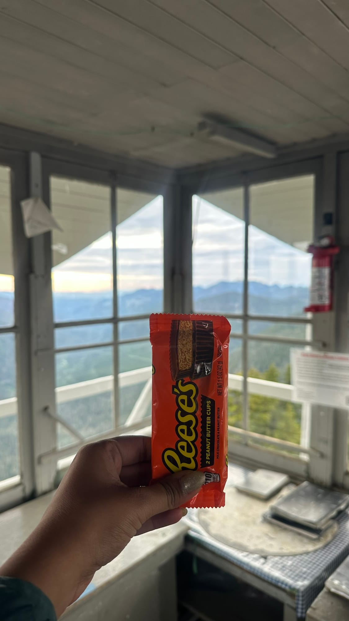 Reese's inside the lookout at dusk, mountains through the windows behind