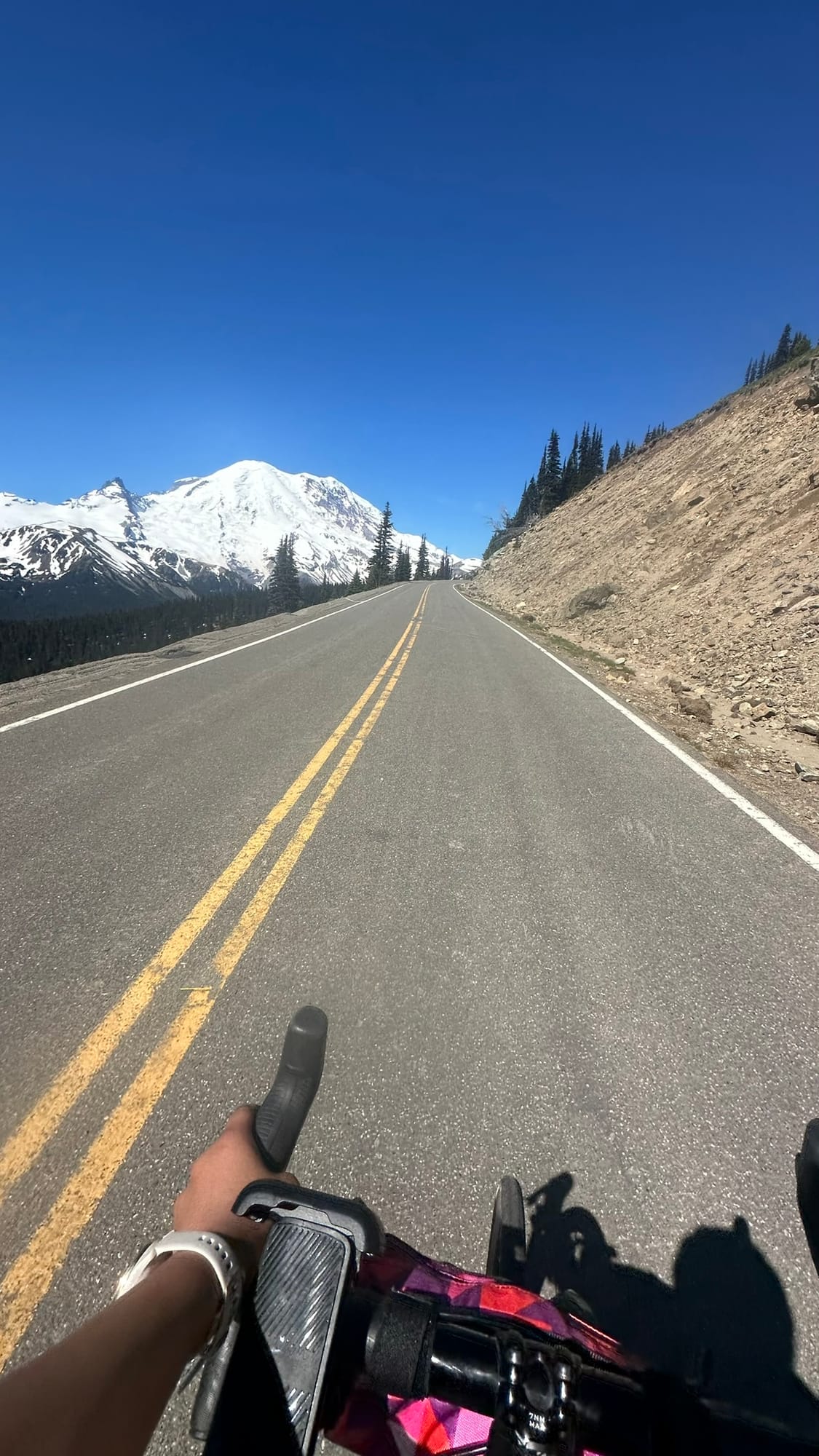 Handlebar POV riding toward Rainier on the open high-elevation road